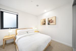 En eller flere senge i et værelse på Sleek Inner-City 2-Bed with Swimming Pool & BBQ + 38 billeder