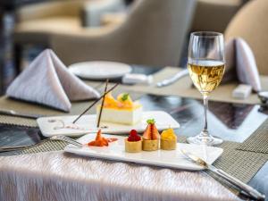 a table with a plate of food and a glass of wine at Shanghai Fuyue Hotel in Songjiang
