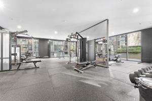 une salle de sport avec tapis de course et machines dans un bâtiment dans l'établissement Refined 2-Bed With Luxurious Building Amenities, à Belconnen