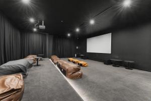 Cette grande chambre dispose de canapés et d'un écran de projection. dans l'établissement Refined 2-Bed With Luxurious Building Amenities, à Belconnen 55 autres photos