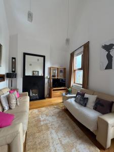 Una sala de estar con dos sofás y una chimenea. en Unique Duplex Apartment in the heart of Dalkey with 2 Luxurious Bedrooms, en Dalkey