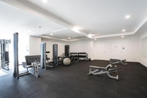 a gym with several treadmills and machines in a room at Modern 1-Bed Unit with Pool Views and Balcony in Canberra