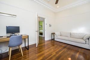 Una sala de estar con un sofá y un escritorio. en Incredible 3-Bed Renovated Home with Huge Garden, en Perth