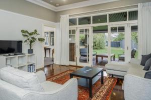 Una sala de estar con muebles blancos y una gran ventana. en Incredible 3-Bed Renovated Home with Huge Garden, en Perth