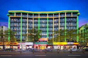 a large building with green lights in front of it at GreenTree Inn Haikou City Wuzhishan Road in Haikou