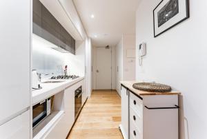 a kitchen with white cabinets and a counter top at "Nott's Nook"- 1-Bed with Rooftop Views in Melbourne