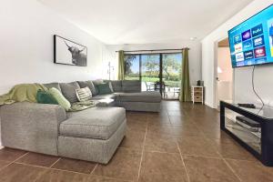 Golf and Tennis Community - Peaceful Pond Paradise - Pet friendly في ويسلي شابل: غرفة معيشة مع أريكة وتلفزيون بشاشة مسطحة