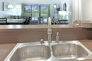 Golf and Tennis Community - Peaceful Pond Paradise - Pet friendly في ويسلي شابل: وجود مغسلة مطبخ مطلة على غرفة معيشة +44 صورة