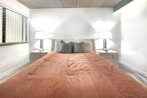 Golf and Tennis Community - Peaceful Pond Paradise - Pet friendly في ويسلي شابل: سرير كبير في غرفة بيضاء فيها مصباحين