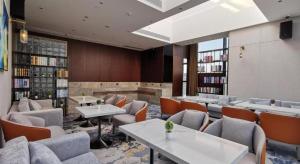 une bibliothèque avec des canapés, des tables et des livres dans l'établissement Derayco Hotel Foshan, à Shunde