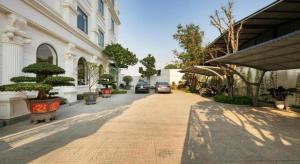 une rue avec un bâtiment et des voitures garées dessus dans l'établissement Chin Luc Hotel, à Ðồng Phú