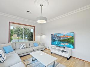 Μια τηλεόραση ή/και κέντρο ψυχαγωγίας στο 4-Bed Beach House with Garden & Alfresco Dining