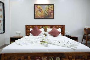 une chambre avec deux lits et un tableau au mur dans l'établissement Sai Dhara Resort,  11 autres photos