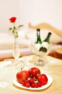 einen Teller Äpfel auf dem Tisch mit Flaschen Champagner in der Unterkunft Pension Waldwinkel in Lenzkirch