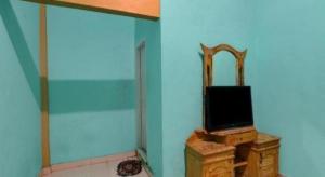 un téléviseur posé sur un meuble dans une pièce dans l'établissement Hotel O Rania Kost Simpang Rimbo, à Kinati