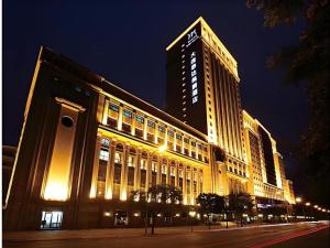 ein großes, nachts beleuchtetes Gebäude in der Unterkunft Grand Mercure Teda Dalian in Dalian