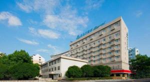 ein großes Gebäude mit einem blauen Schild darüber in der Unterkunft Jinjiang Inn Style Ningbo Railway Station in Ningbo