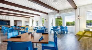 ein Esszimmer mit blauen Stühlen, Tischen und Fenstern in der Unterkunft Tan-Tar-A Estates in Damsel