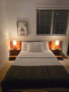 um quarto com uma cama grande com duas lâmpadas em Comfortable Luxury Studio em Northridge