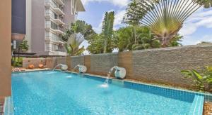 a swimming pool in front of a building at Chic Residences at Karon Beach in Karon Beach