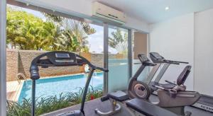 a gym with two exercise bikes and a swimming pool at Chic Residences at Karon Beach in Karon Beach