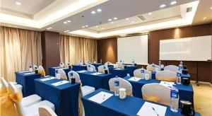 a conference room with blue tables and white chairs at Jinjiang Metropolo Hotel - Langfang Wanda Plaza in Langfang