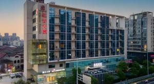 ein großes Gebäude mit vielen Fenstern in einer Stadt in der Unterkunft Jinjiang Inn Changzhou Global Dinosaur City Olympic Center in Changzhou