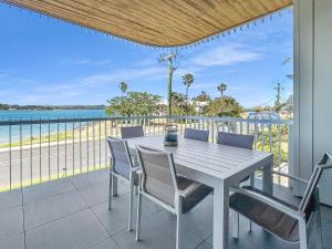 Una mesa y sillas en un balcón con vista al mar. en 3-Bed: Riverfront Alfresco Dining & Rooftop Pool, en Batemans Bay 26 fotos más