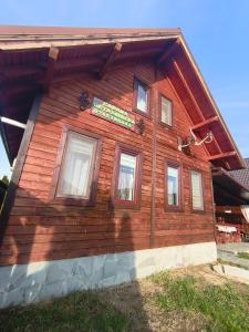 une maison en bois avec des fenêtres latérales dans l'établissement Cabana Geta&Mircea, à Beclean