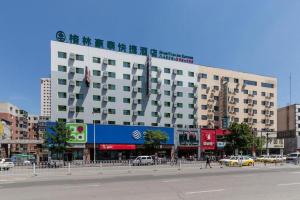 ein großes weißes Gebäude in einer Stadtstraße mit Autos in der Unterkunft GreenTree Inn Shenyang Shenhe District Wuai Street in Shenyang