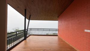 uma varanda vazia com uma parede de tijolos vermelhos em The Miste Munnar By D2V em Munnar