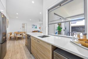 Η κουζίνα ή μικρή κουζίνα στο Premium 4-Bed Coastal Escape with BBQ and Pool