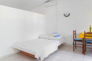 a white bedroom with a bed and a desk at Ante Apartments in Trstenik