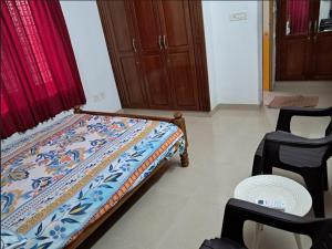 a bedroom with a bed and two chairs in it at 3 BHK House in Trichūr