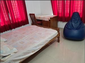 a bedroom with a bed and a chair and red curtains at 3 BHK House in Trichūr +3 photos