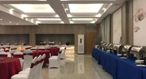 a large room with red and white tables and chairs at Mercure Styles Hotel Meizhou in Meizhou +91 photos