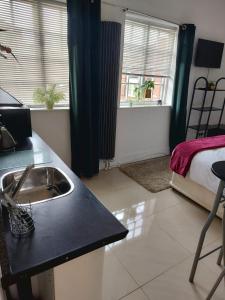 Una cocina con fregadero y una cama en una habitación. en Cambridge suites, en Cleethorpes 24 fotos más