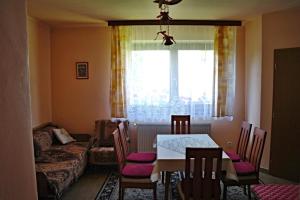 jadalnia ze stołem i krzesłami oraz oknem w obiekcie Penzion Jaraba w Żarze