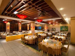 einen Bankettsaal mit weißen Tischen, Stühlen und einem Tischler in der Unterkunft Yuhai International Resort Hotel in Sanya