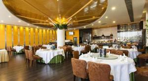 a dining room with white tables and chairs at Shenzhen Dameishawan Youtinghui Hotel in Shenzhen