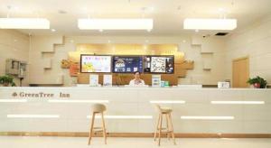 a woman sitting at a counter in a store at GreeTree Inn Huainan Jinjialing Road Oriental General Hospital in Huainan