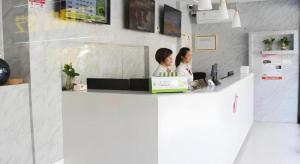 deux femmes sont assises à un comptoir dans une pièce dans l'établissement Shell Shanghai Yangpu District Shuangyang Road Hotel, à Shanghai