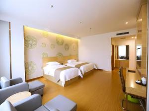 una habitación de hotel con dos camas y un sofá en GreenTree Inn Xi'an Terracotta Warriors Huaqing Pool Metro Station, en Xi'an
