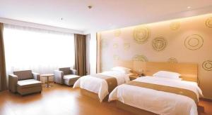 a hotel room with two beds and a chair at GreenTree Inn Xi'an Terracotta Warriors Huaqing Pool Metro Station in Xi'an