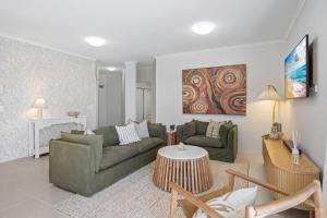 ein Wohnzimmer mit zwei Sofas und einem Tisch in der Unterkunft Stylish 3-Bed Apartment in Coastal Redcliffe in Redcliffe