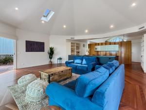 Una sala de estar con sofás azules y una mesa. en Spacious 4-Bed Home with Coastal Charm, en Long Beach