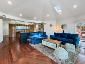 Una sala de estar con sofás azules y una mesa. en Spacious 4-Bed Home with Coastal Charm, en Long Beach
