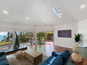 Una sala de estar con un sofá azul y una mesa. en Spacious 4-Bed Home with Coastal Charm, en Long Beach 34 fotos más