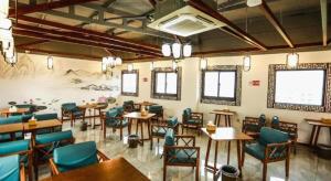 ein Restaurant mit Tischen und Stühlen und einem Gemälde an der Wand in der Unterkunft LANO Hotel Anhui Suzhou Yongqiao District Yingbin Avenue in Suzhou