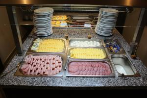 a counter with trays of different types of food at Royal Plaza in Prague